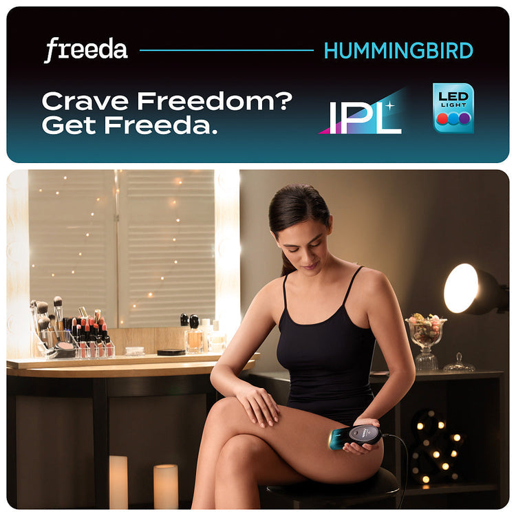 Woman using Freeda Hummingbird IPL device in a dimly lit room.