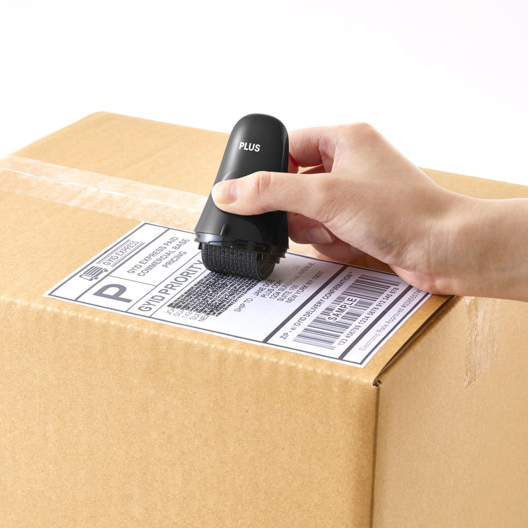 Hand applying a barcode label to a cardboard box using a label printer.