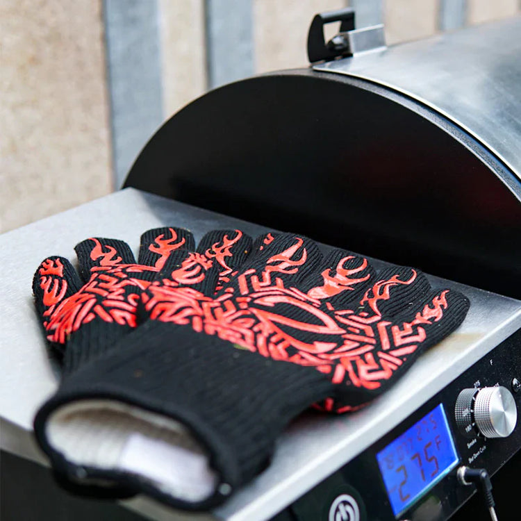 Black and red patterned gloves on a grill with a digital display
