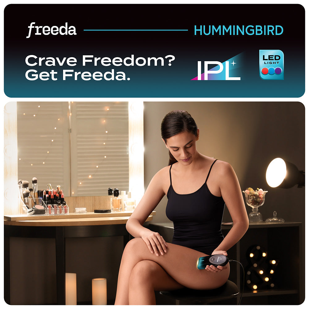 Woman using Freeda Hummingbird IPL device in a dimly lit room.