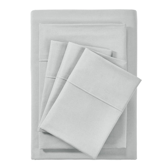 A silver 6-piece bamboo sheet set on a bed, including a fitted sheet, a flat sheet, and pillowcases, presented in a well-lit room with a plant and nightstand beside the bed.