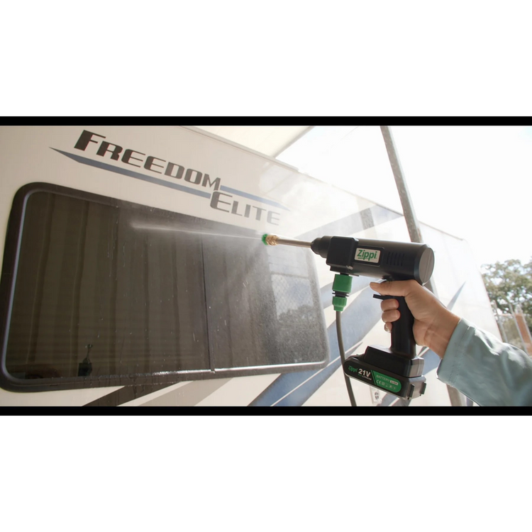 Person cleaning an RV window with a power washer labeled 'Freedom Elite'.