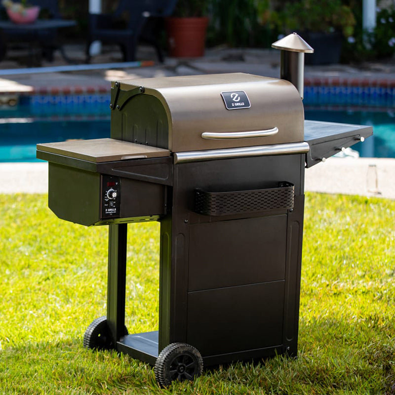 Barbecue grill on grass with pool in the background