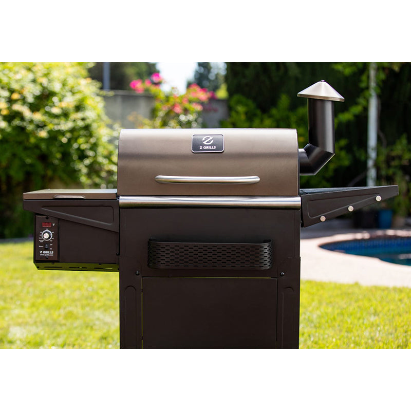Z-Grill barbecue grill in a backyard setting with greenery and a pool.