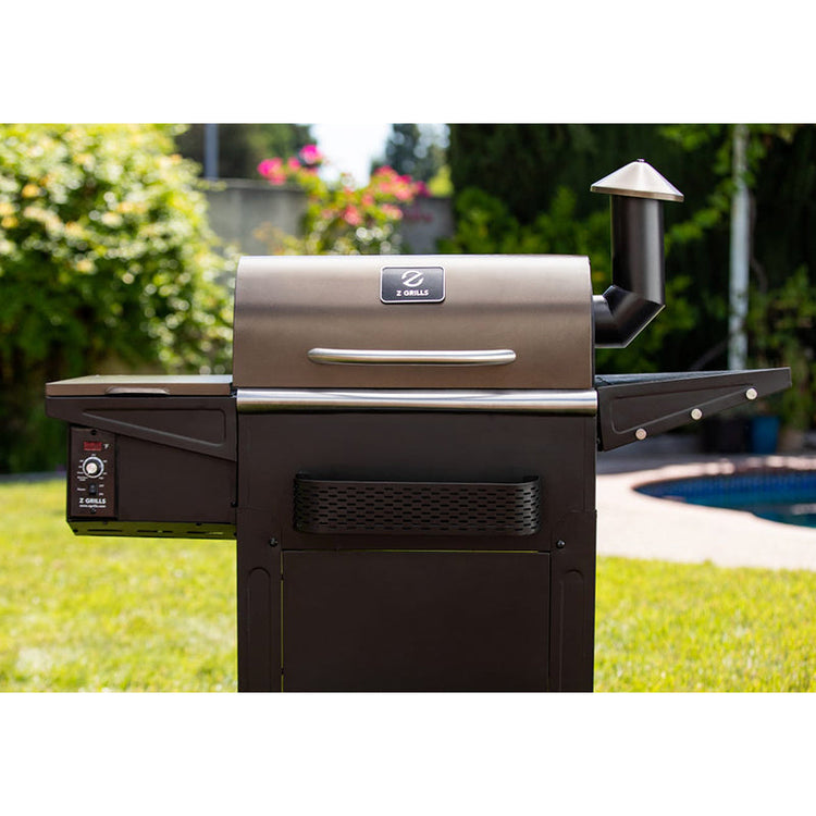 Z-Grill barbecue grill in a backyard setting with greenery and a pool.