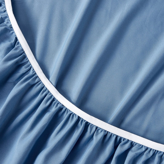 A set of ocean blue bamboo sheets displayed on a bed, including a fitted sheet, a flat sheet, and pillowcases.