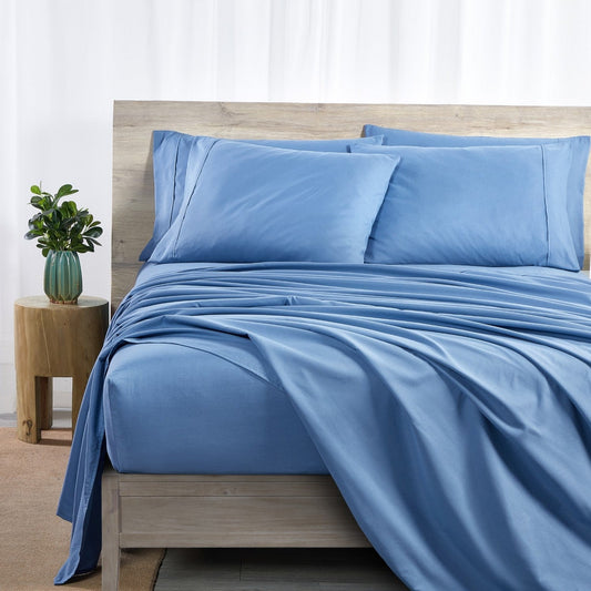A set of ocean blue bamboo sheets displayed on a bed, including a fitted sheet, a flat sheet, and pillowcases.