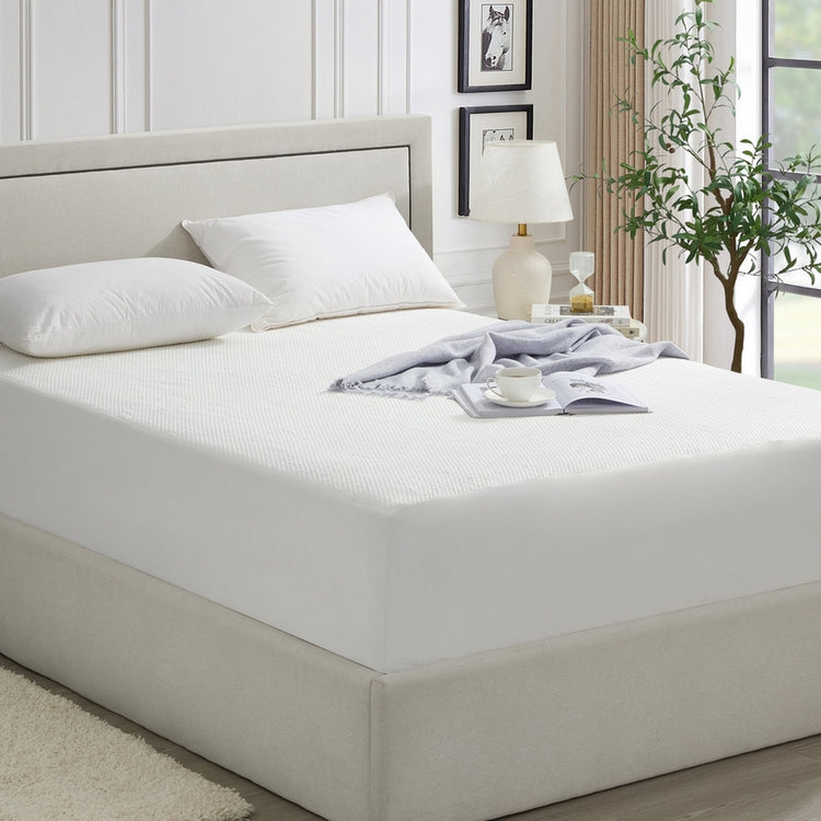 Bed with white bedding and a nightstand in a bedroom setting