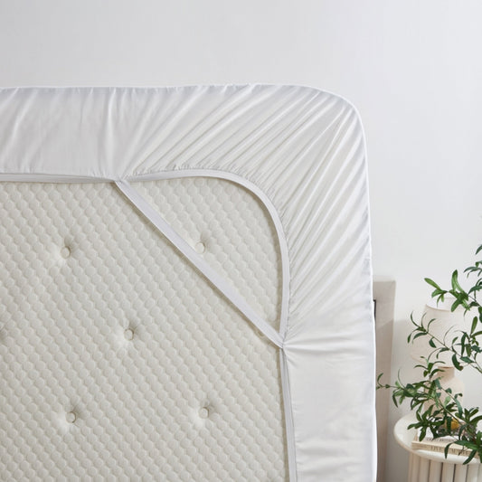 Bed with white bedding and a nightstand in a bedroom setting