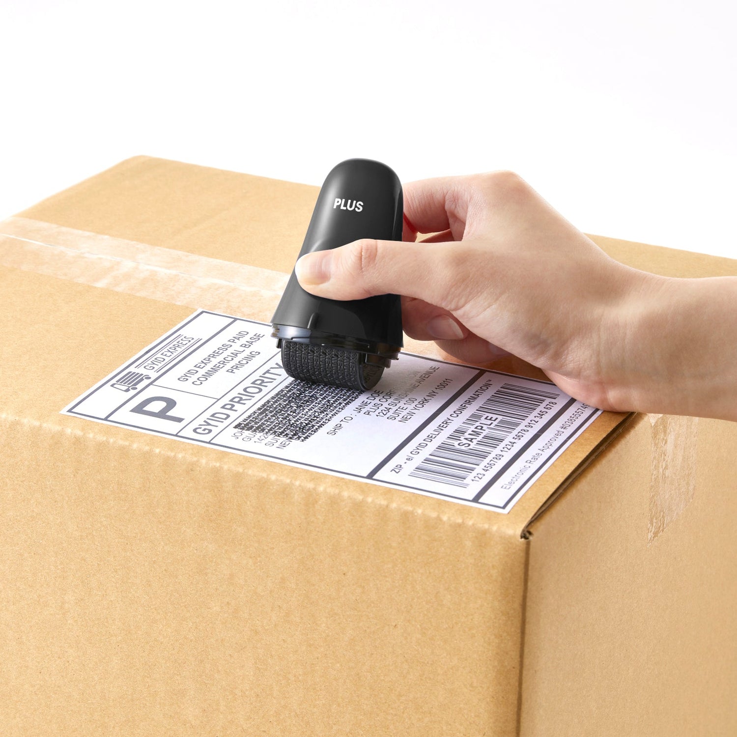 Hand applying a barcode label to a cardboard box using a label printer.