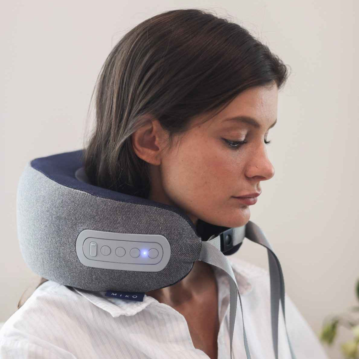 Woman using a neck massager with a white background