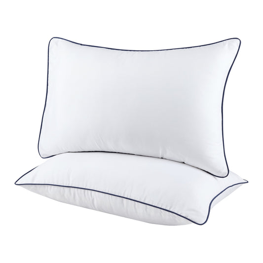 Two white pillows with black piping on a white background