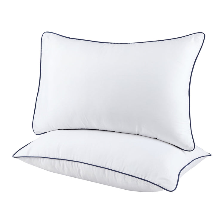 Two white pillows with black piping on a white background