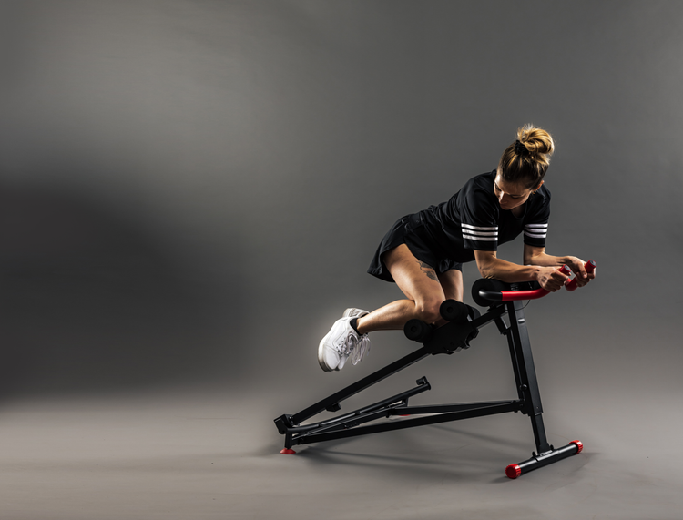 Person using a stationary bike against a gray background