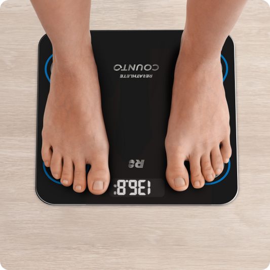 A black digital smart scale with blue decorative elements and silver brand logos, displaying a weight reading.