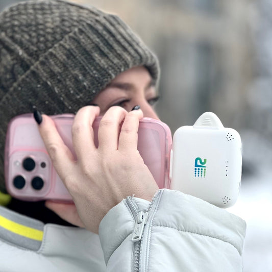 Four portable battery chargers in different colors: pink, blue, white, and black, each with a label displaying the brand.