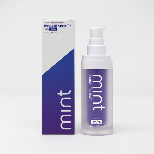 A product image showing a box and tube of Mint InstantPurple Color Corrector with nHAp. The packaging is primarily purple and white with text detailing the product's benefits and instructions for use.