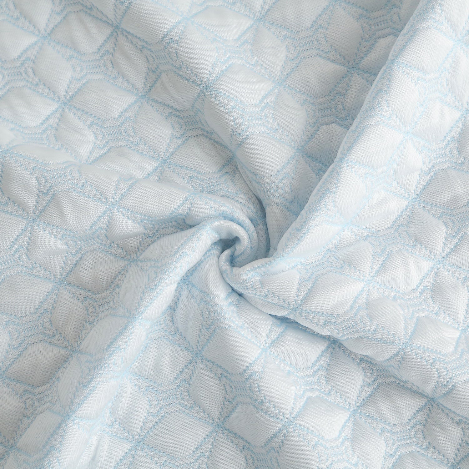 Close-up of a quilt with a blue grid pattern on a white background